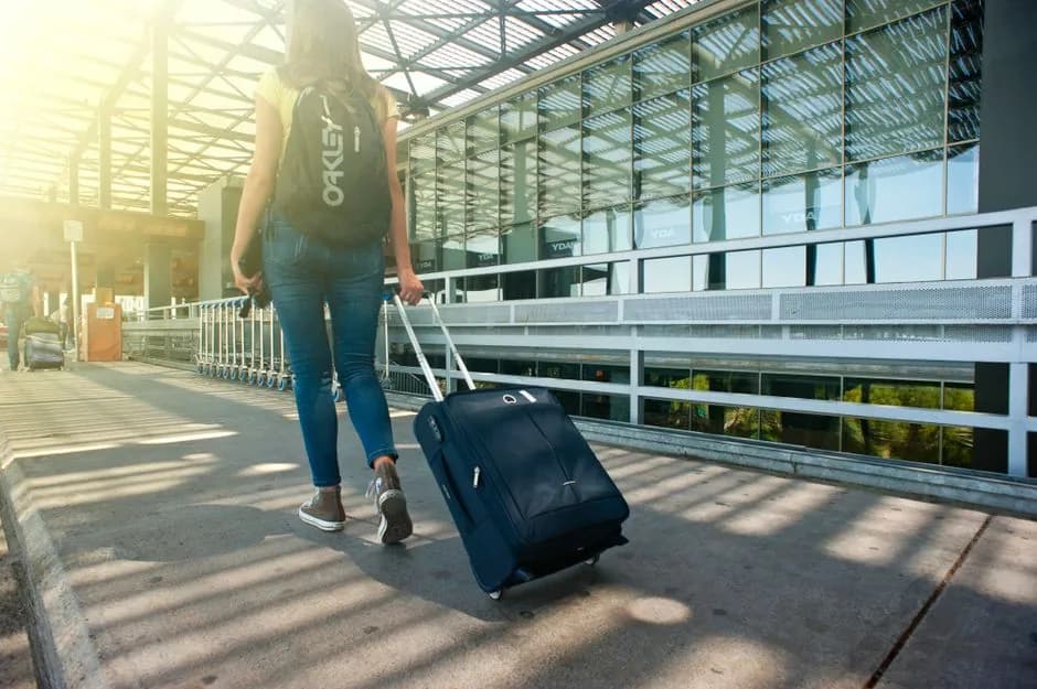 A person pulling a suitcase through an airport terminal